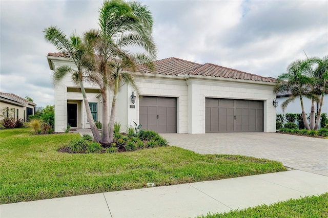 mediterranean / spanish-style house featuring a front yard and a garage