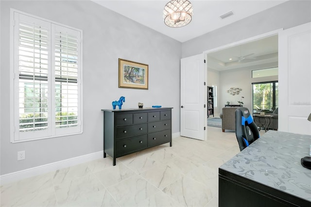 home office featuring marble finish floor, a raised ceiling, visible vents, and baseboards