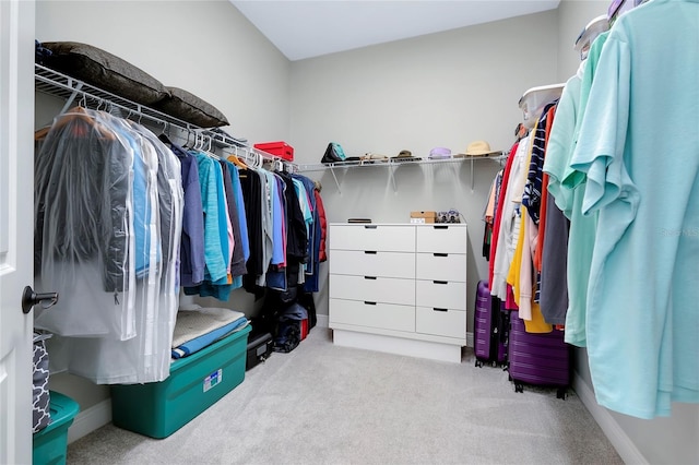 walk in closet with light carpet