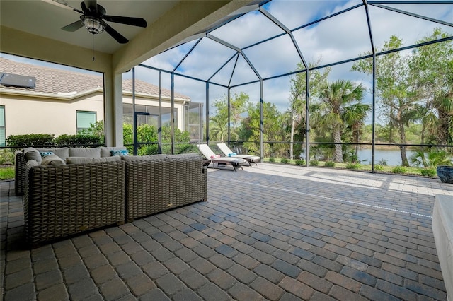 view of patio with outdoor lounge area, ceiling fan, a water view, and glass enclosure