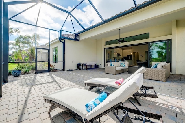 view of patio / terrace featuring glass enclosure, outdoor lounge area, and a ceiling fan