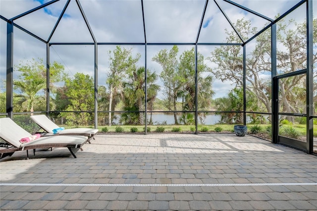 view of patio with a water view and a lanai