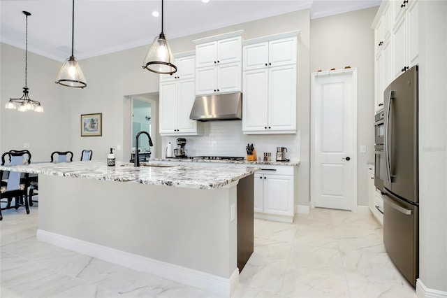 kitchen featuring white cabinetry, sink, stainless steel fridge, decorative light fixtures, and a center island with sink