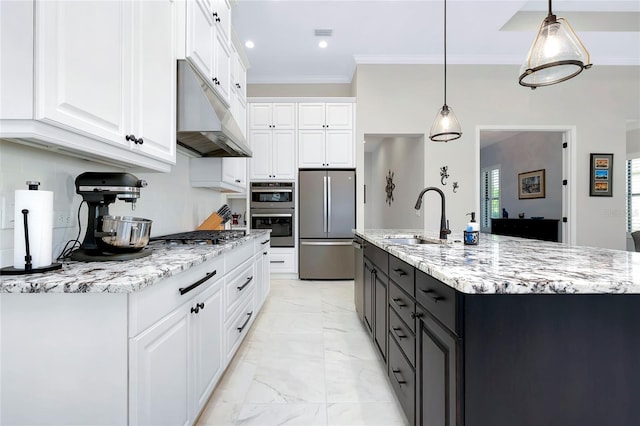 kitchen featuring sink, hanging light fixtures, an island with sink, appliances with stainless steel finishes, and white cabinetry