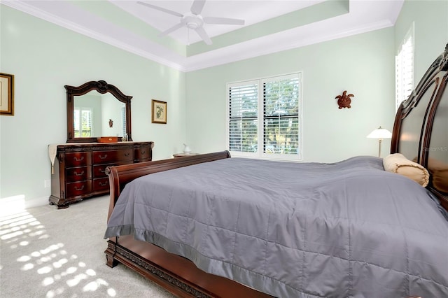 bedroom with a raised ceiling, carpet flooring, crown molding, and baseboards