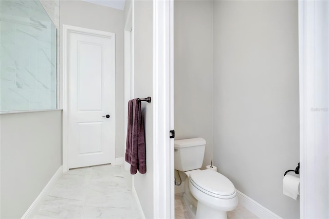 bathroom featuring marble finish floor, toilet, and baseboards