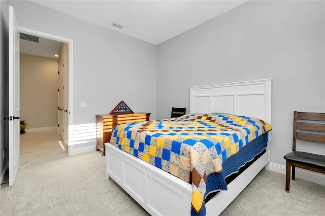 bedroom with light carpet, visible vents, and baseboards