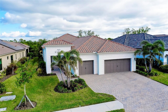 mediterranean / spanish house featuring a garage and a front yard