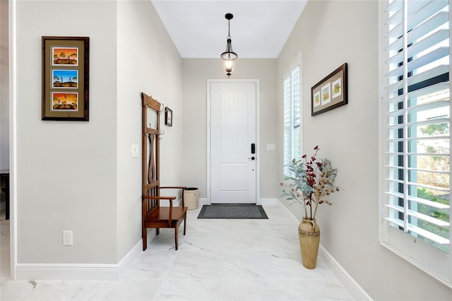 entrance foyer with marble finish floor and baseboards