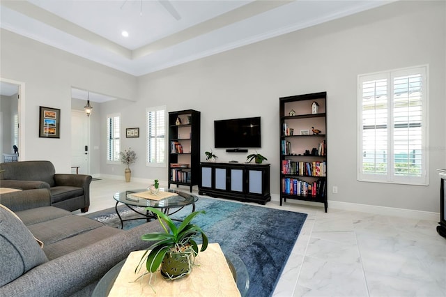 living area with marble finish floor, recessed lighting, a raised ceiling, and baseboards