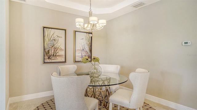 dining room featuring an inviting chandelier and a raised ceiling