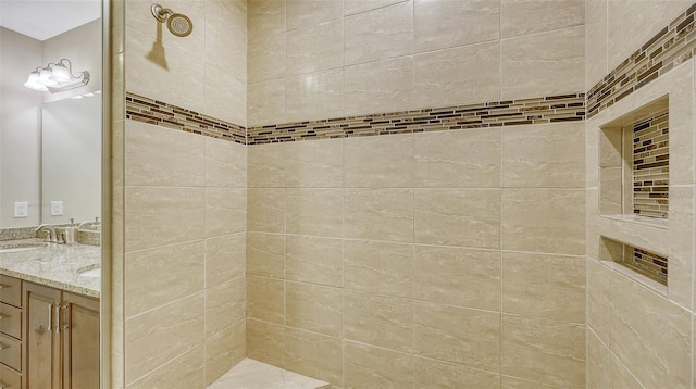 bathroom featuring a tile shower and vanity