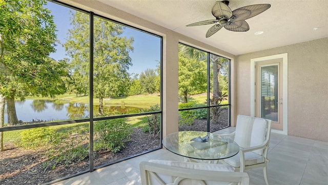 unfurnished sunroom featuring a water view and ceiling fan