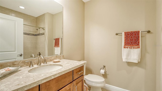 bathroom featuring vanity, toilet, and tiled shower