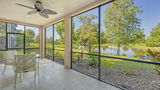 unfurnished sunroom featuring a water view and ceiling fan