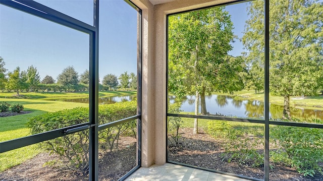 unfurnished sunroom featuring a water view