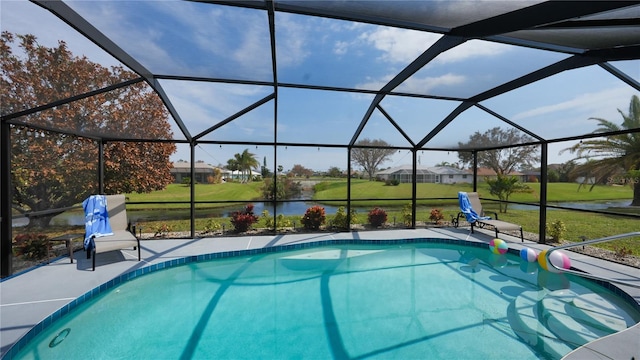 view of pool featuring glass enclosure and a lawn