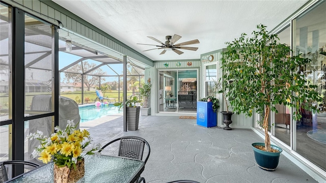 unfurnished sunroom with a swimming pool and ceiling fan