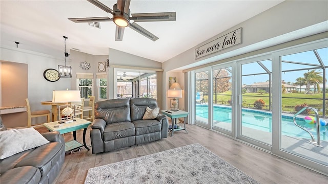 living room with vaulted ceiling, light hardwood / wood-style flooring, and plenty of natural light