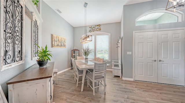 dining room with lofted ceiling and light wood-type flooring