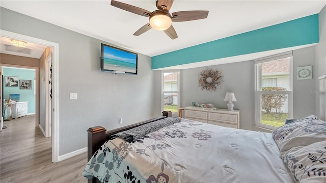 bedroom with ceiling fan and light hardwood / wood-style floors