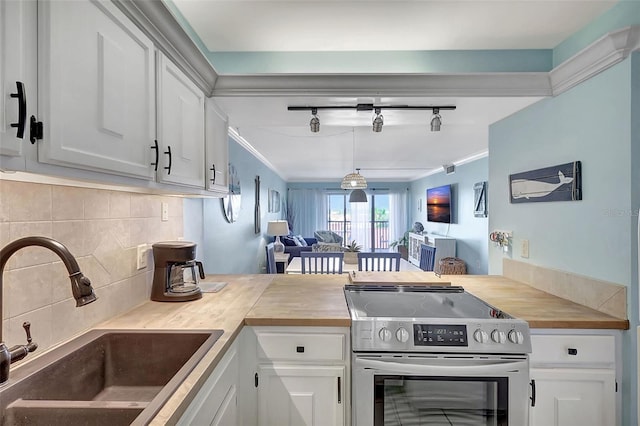 kitchen featuring rail lighting, sink, electric stove, white cabinets, and butcher block counters