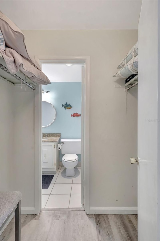 bathroom featuring vanity, wood-type flooring, and toilet