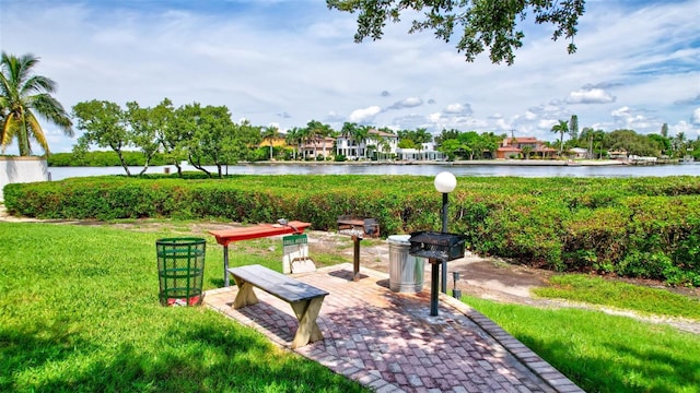 view of home's community with a lawn and a water view