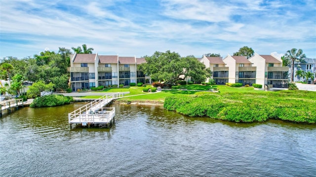 view of dock with a yard and a water view