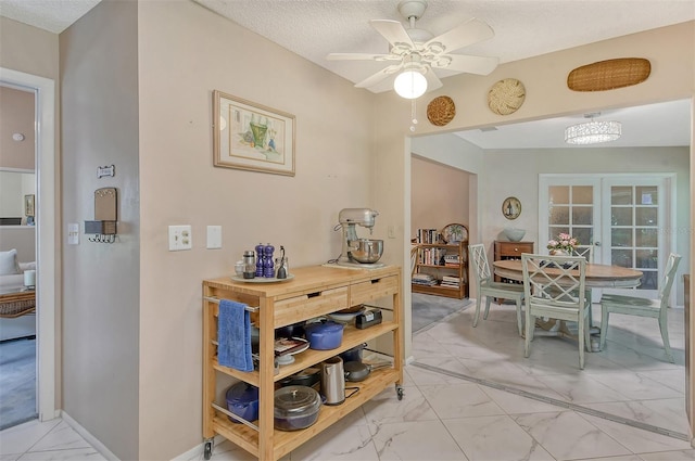 dining room featuring french doors, ceiling fan, and a textured ceiling