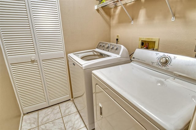 laundry area with light tile patterned floors and washer and dryer