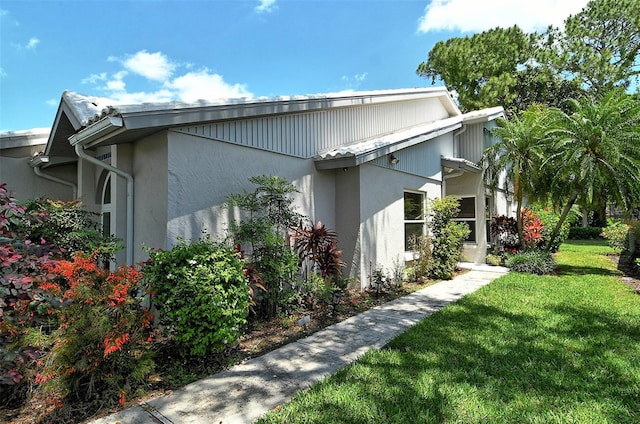 view of side of home with a lawn