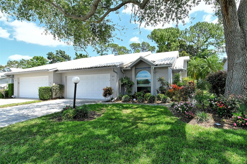 single story home with a front yard and a garage