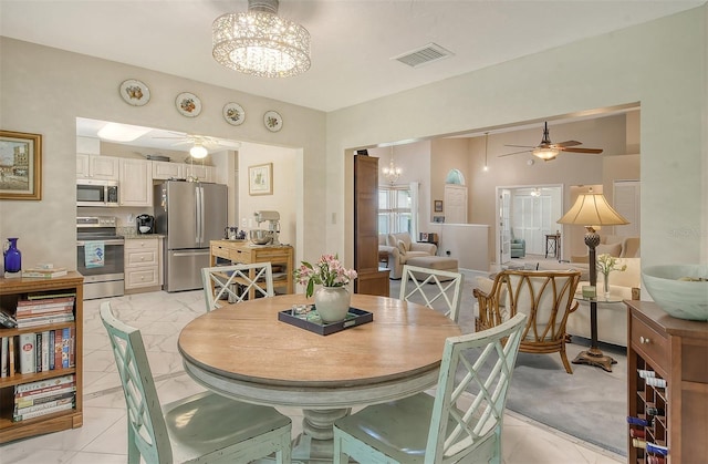 dining room featuring ceiling fan with notable chandelier