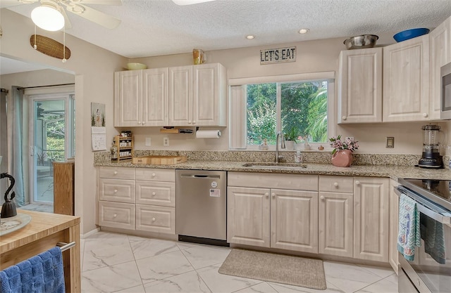 kitchen featuring ceiling fan, a healthy amount of sunlight, stainless steel appliances, and sink