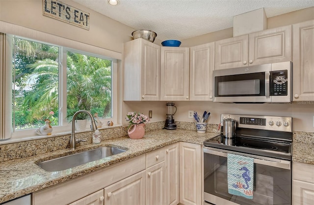 kitchen featuring a wealth of natural light, stainless steel appliances, and light stone countertops