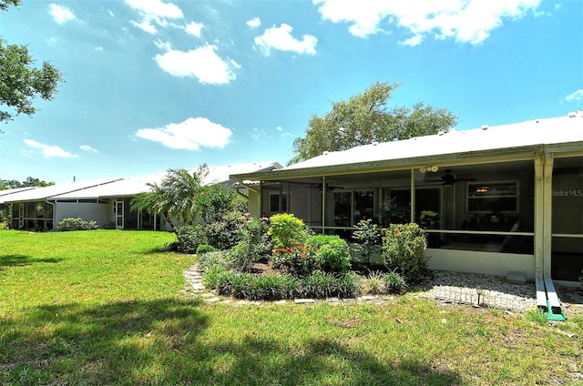 back of property with a sunroom and a lawn