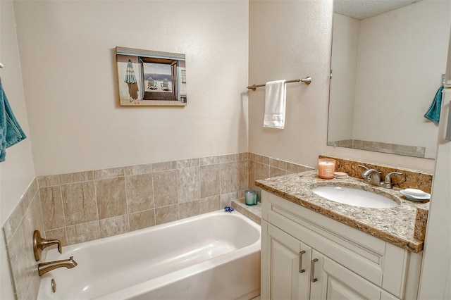 bathroom featuring a bathtub, a textured ceiling, and vanity