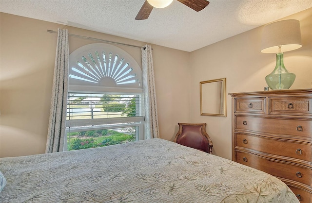 bedroom with a textured ceiling and ceiling fan