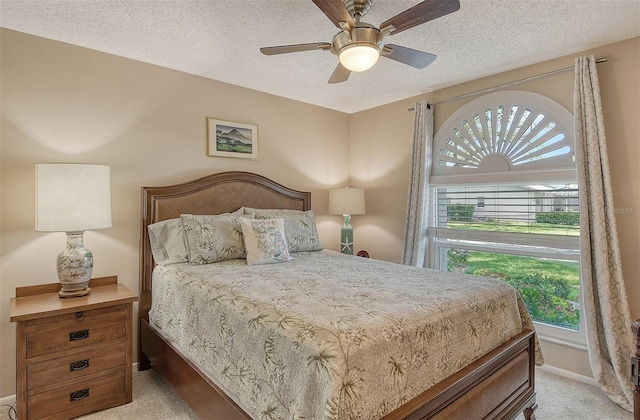 bedroom with light carpet, a textured ceiling, and ceiling fan