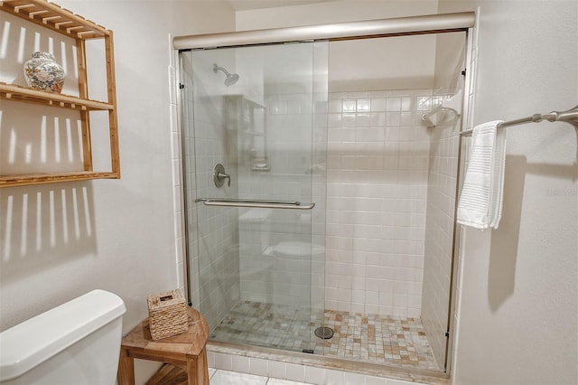 bathroom with a shower with door and toilet