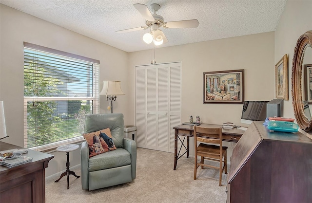 carpeted office space featuring a textured ceiling and ceiling fan