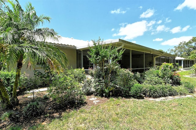 view of front facade featuring a sunroom and a front lawn