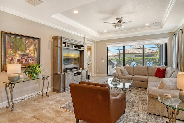 living room featuring a textured ceiling, a tray ceiling, and ceiling fan