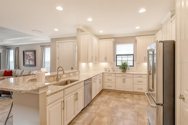 kitchen with a breakfast bar area, appliances with stainless steel finishes, sink, and kitchen peninsula