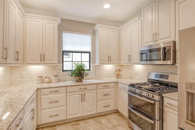 kitchen with decorative backsplash, stainless steel appliances, light stone counters, and white cabinets