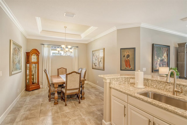 dining space with ornamental molding, a raised ceiling, a chandelier, and sink