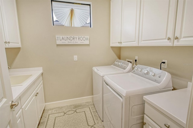 clothes washing area featuring cabinets, sink, and washing machine and dryer