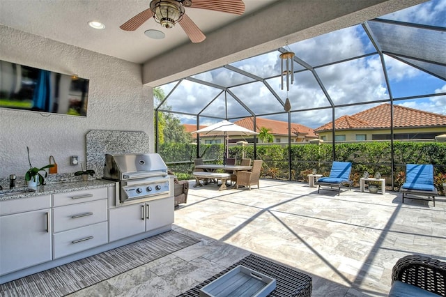 view of patio / terrace with ceiling fan, area for grilling, sink, and a lanai