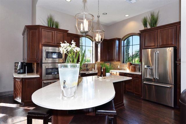 kitchen with stainless steel appliances, a wealth of natural light, and a kitchen island